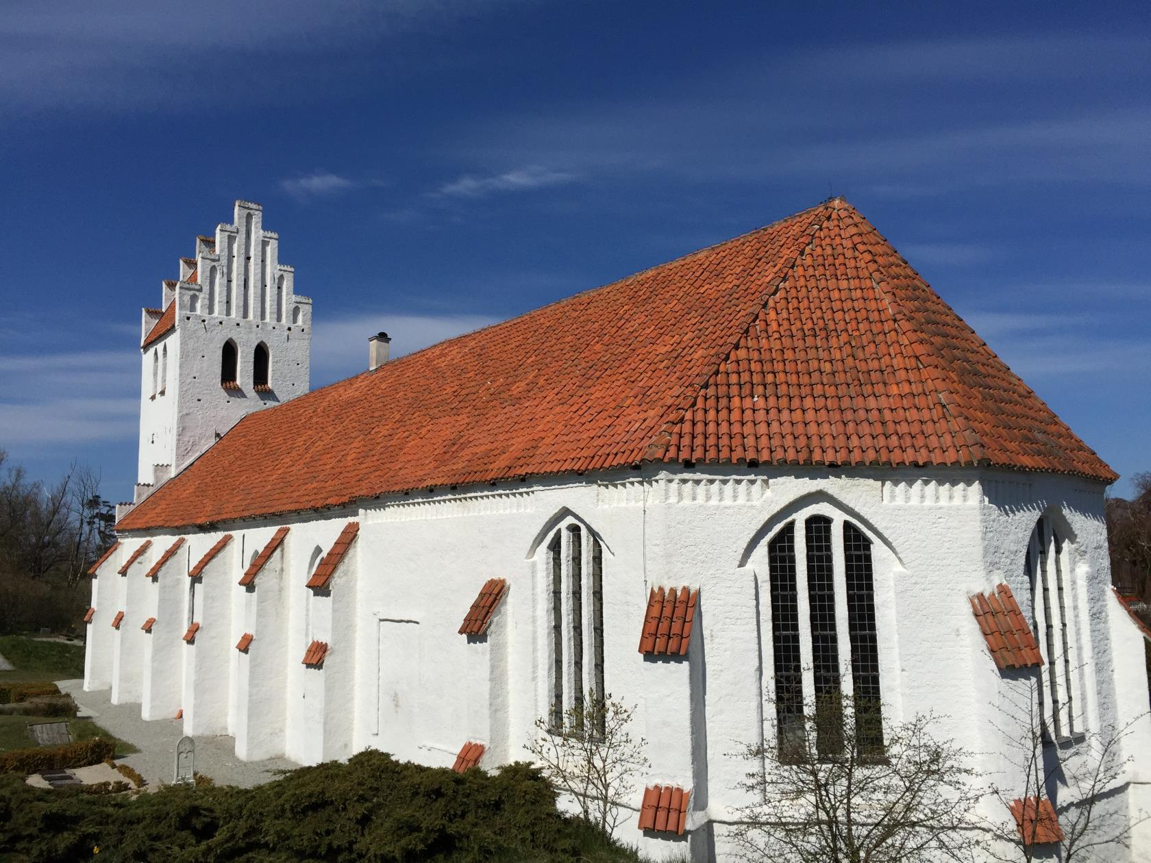 Falsterbo kyrka sedd bakifrån en solig dag med blå himmel.