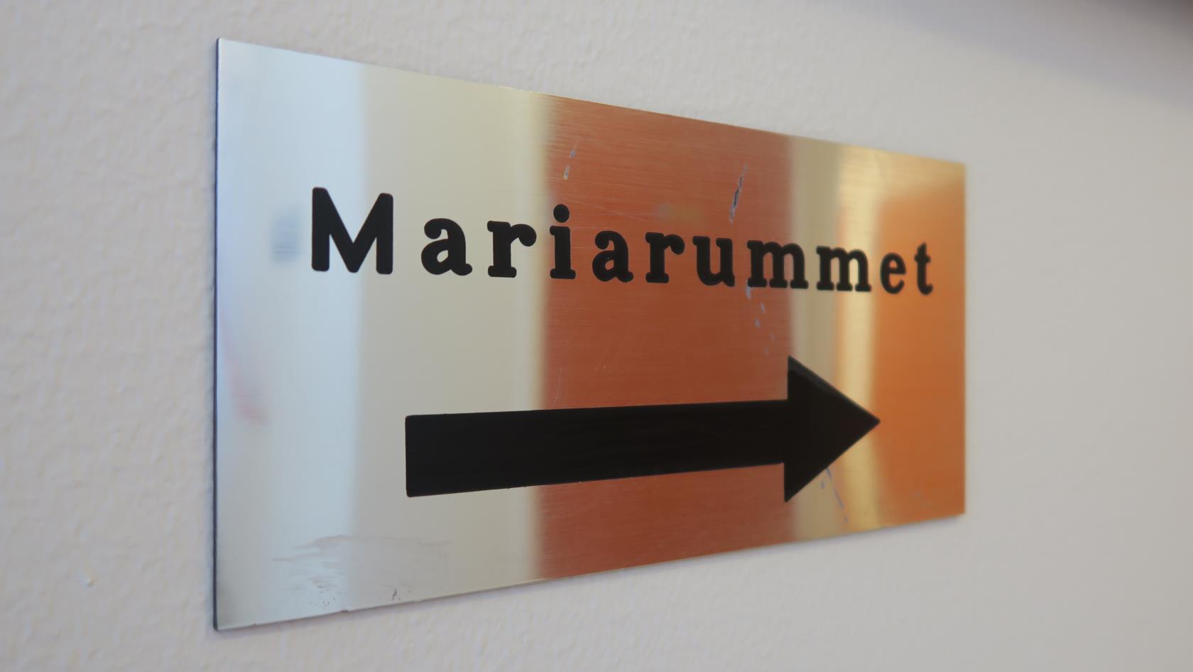 En blank skylt med texten "Mariarummet" och en pil.