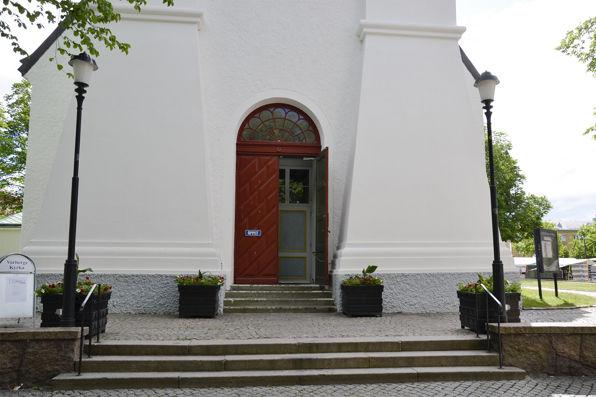 Gaveln på en kyrka med trappor som leder upp till den röda kyrkporten. 