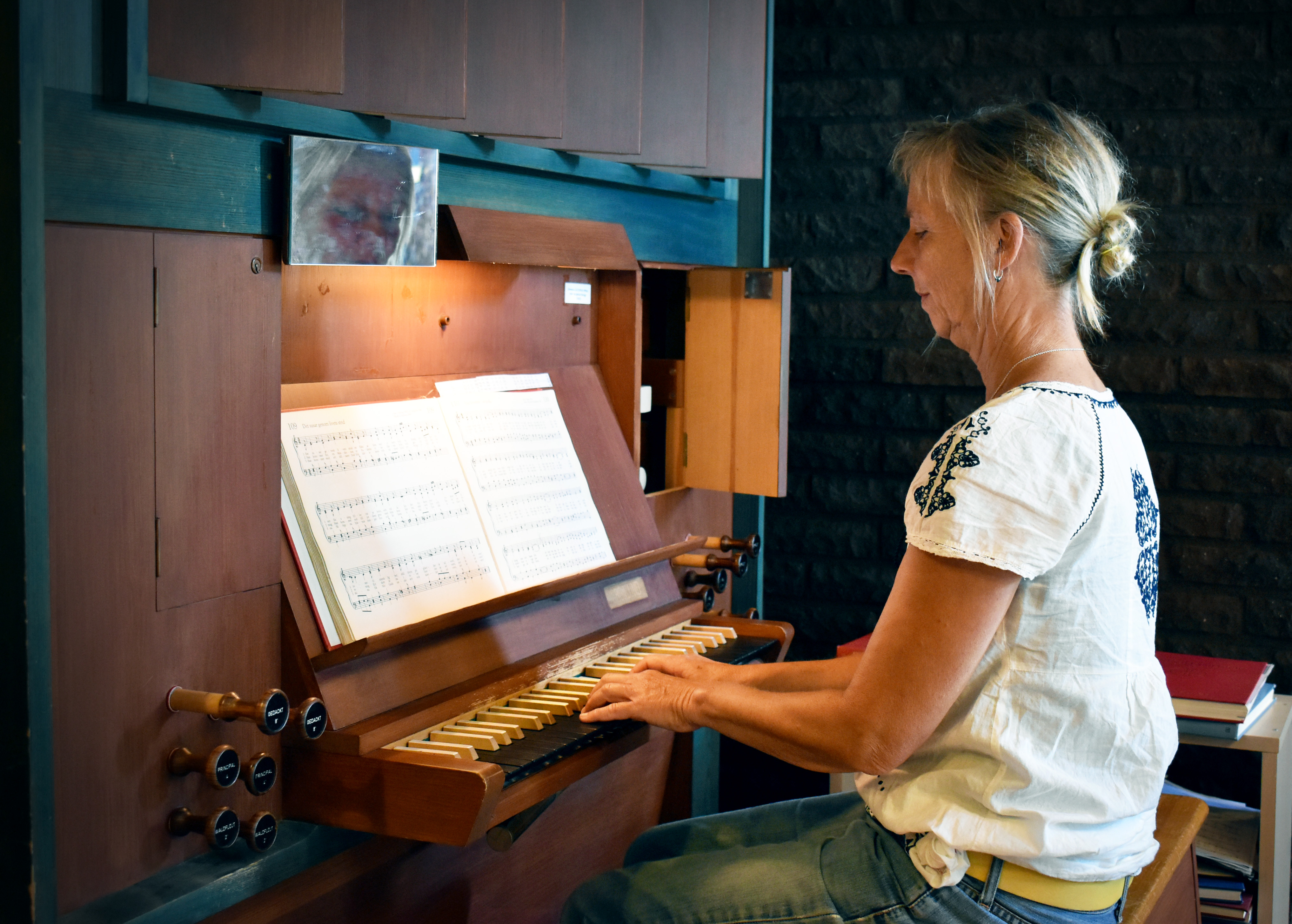 Kvinna spelar på liten kyrkorgel.