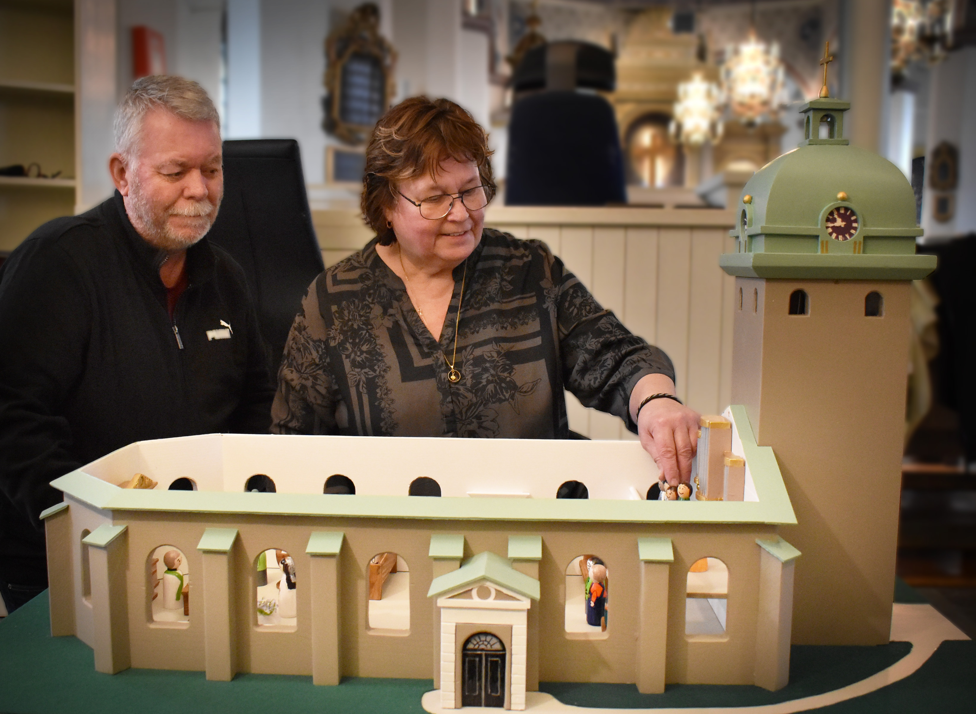 En man och en kvinna med en detaljerad modell av en kyrka.