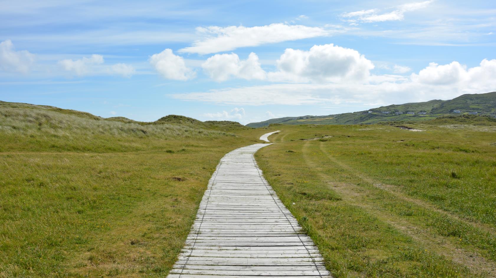 Eng gångväg mot horisonten, blå himmel med vita moln.