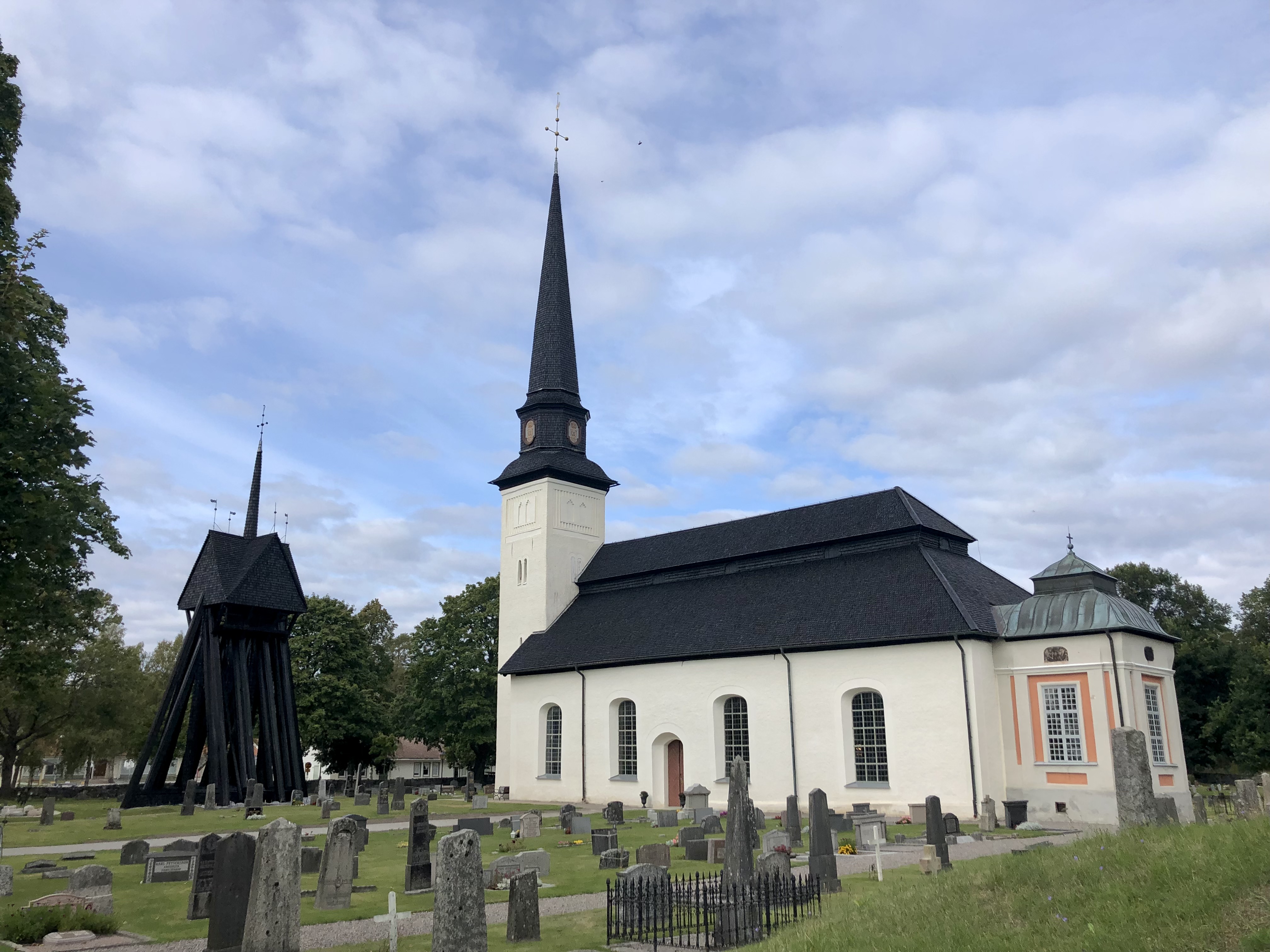 Glanshammars kyrka. Vit kyrka med svart träspånstak med gröna omgivningar