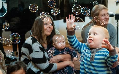 Bebis leker med bubblor på aktivitet i kyrkan för föräldrar och barn.