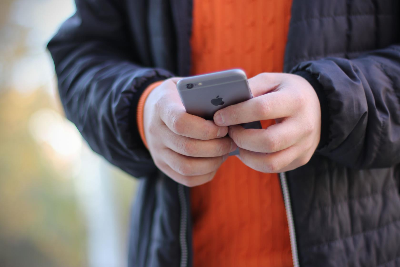 Händer som håller en mobiltelefon