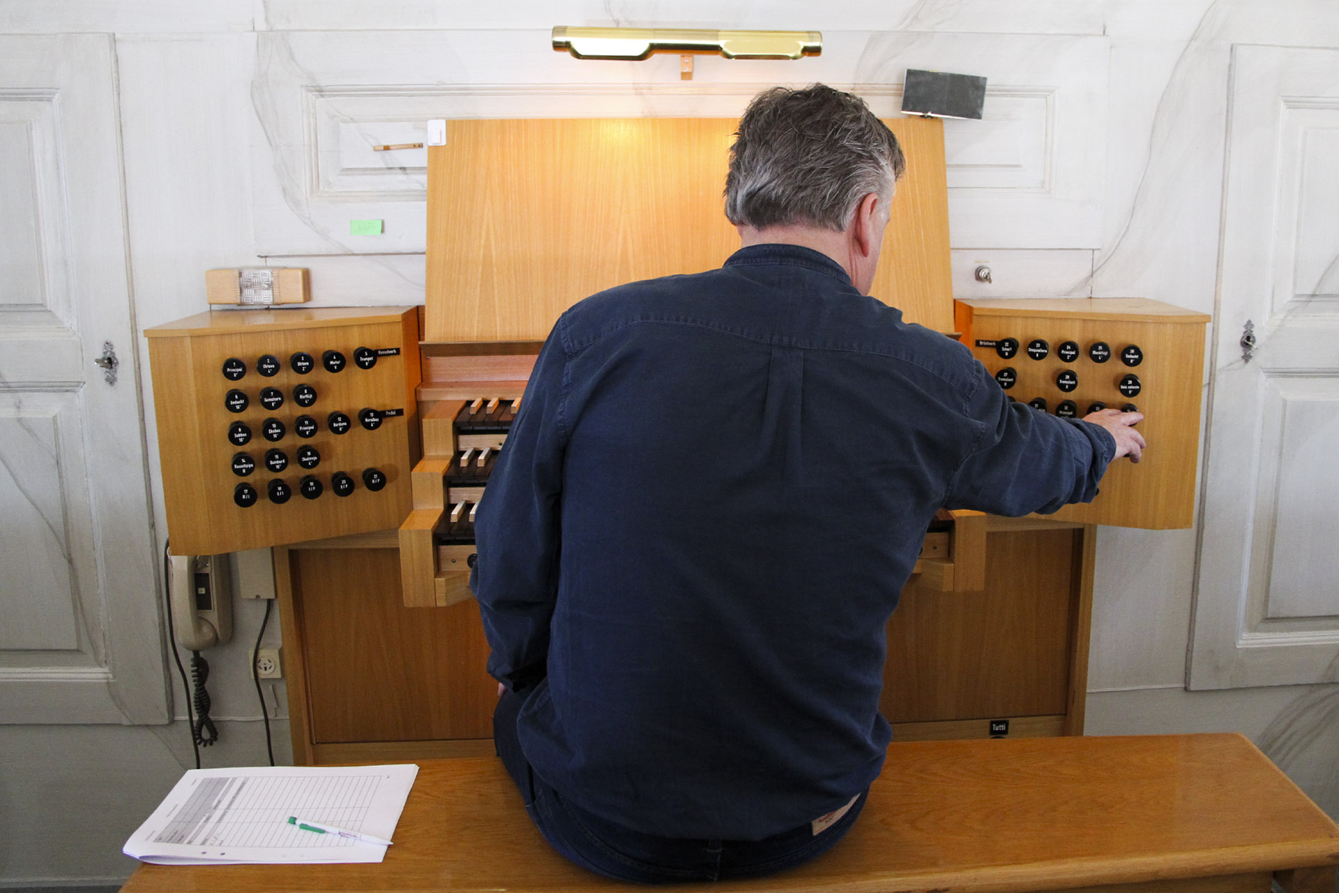 Organisten Håkan Dahlén sitter vid spelbordet för Tuna kyrkas orgel.