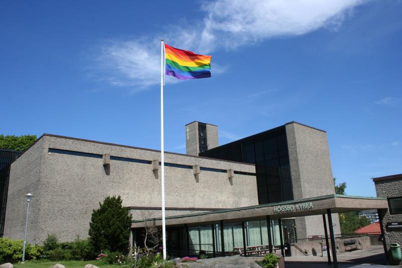 Högsbo kyrka utifrån. HBTQ-flaggan är hissad.