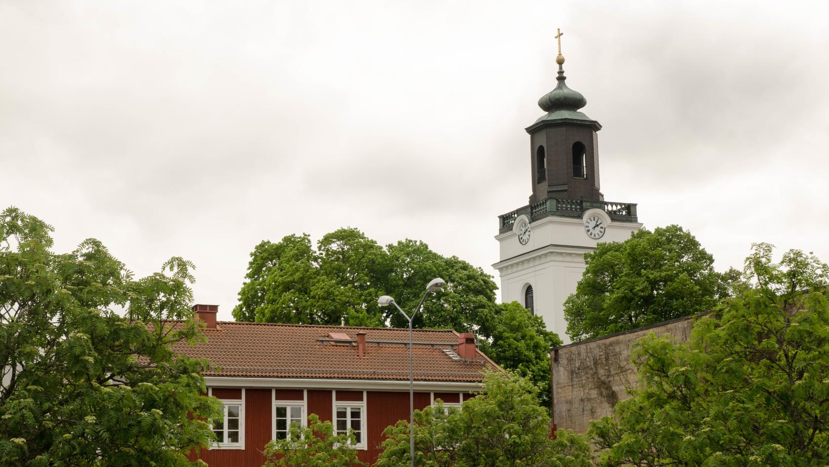 Eksjö kyrkas torn med Kyrkbacksgården framför.