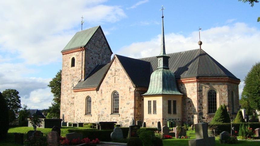 Vallentuna kyrka och kyrkogård, det är sommar och några lätta moln på himlen. 