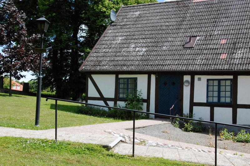 Den vita korsvirkesbyggnaden Kyrkstugan ligger i anslutning till Sövestad kyrka.