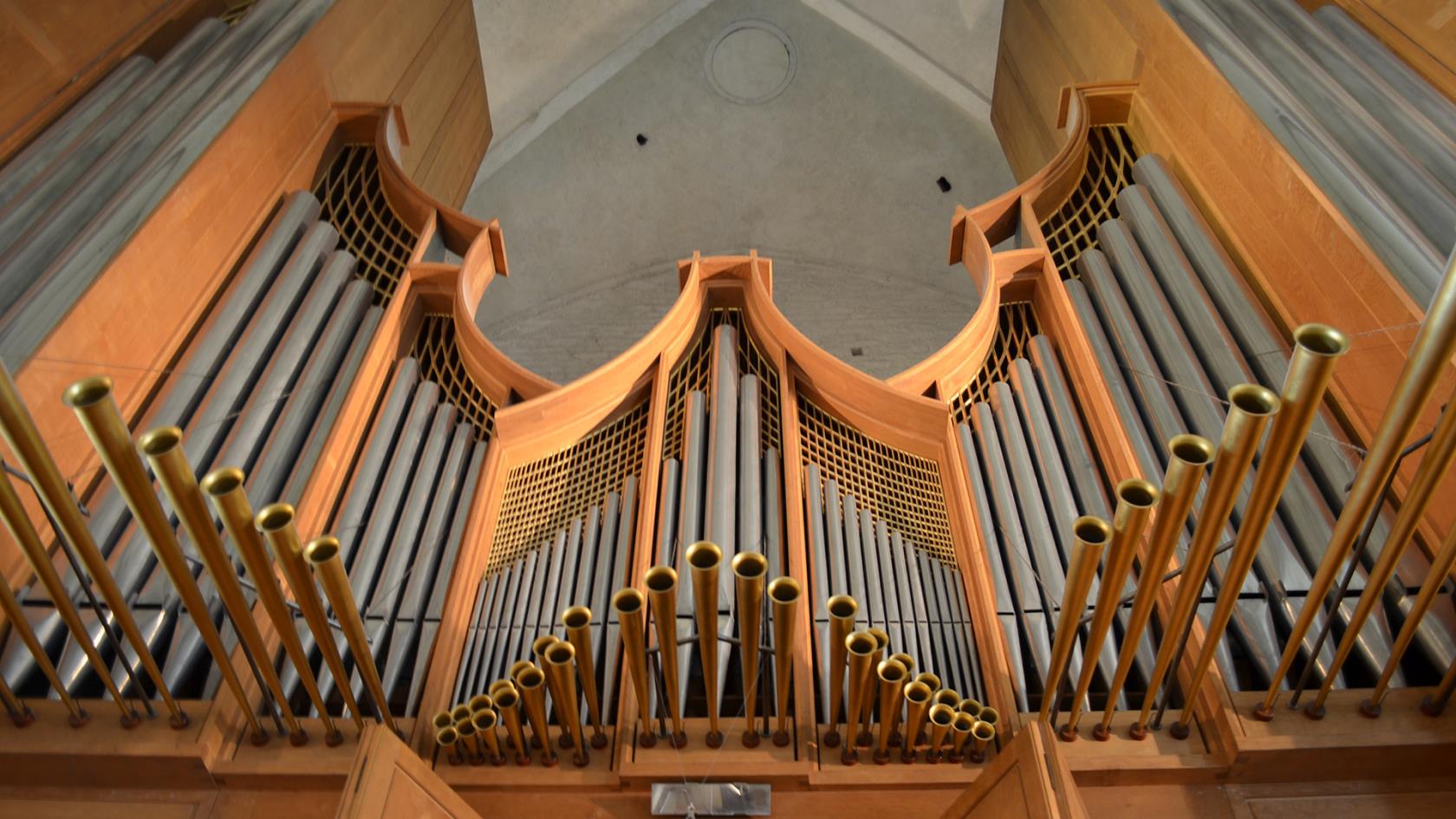 Närbild på en stor orgel med många pipor.