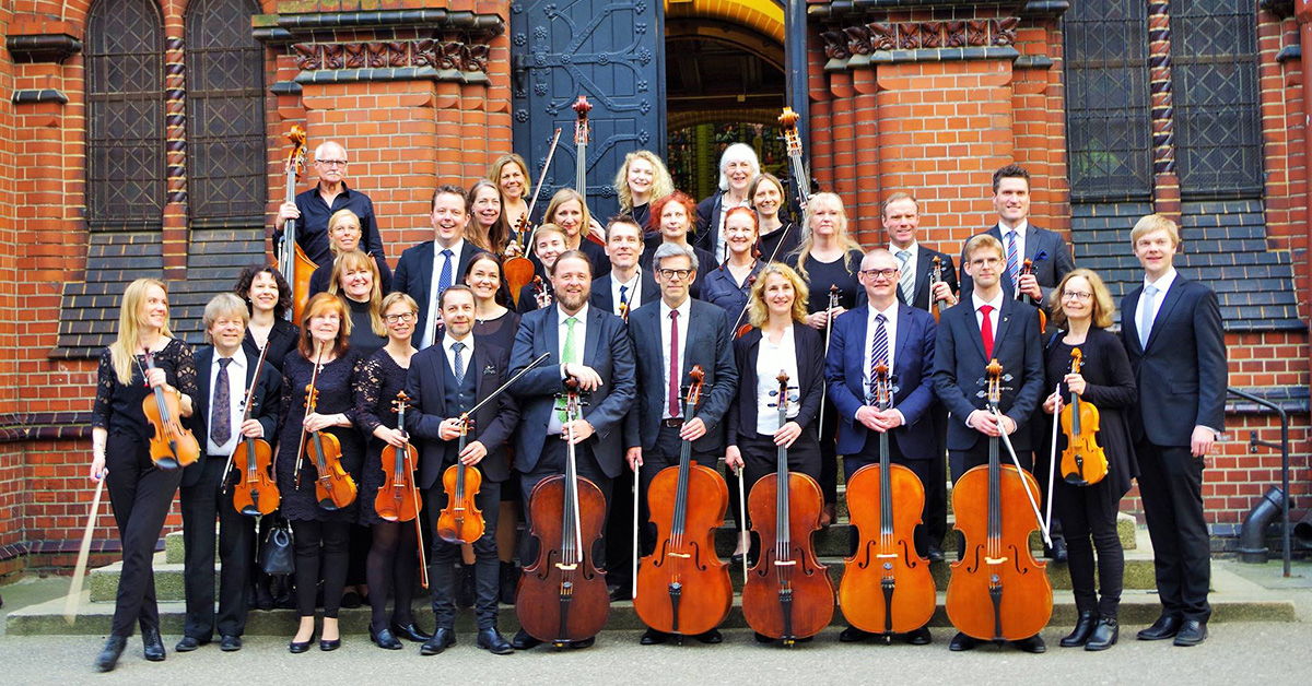 Gruppbild av Sinfoniettan utanför Oscar Fredriks kyrka. 