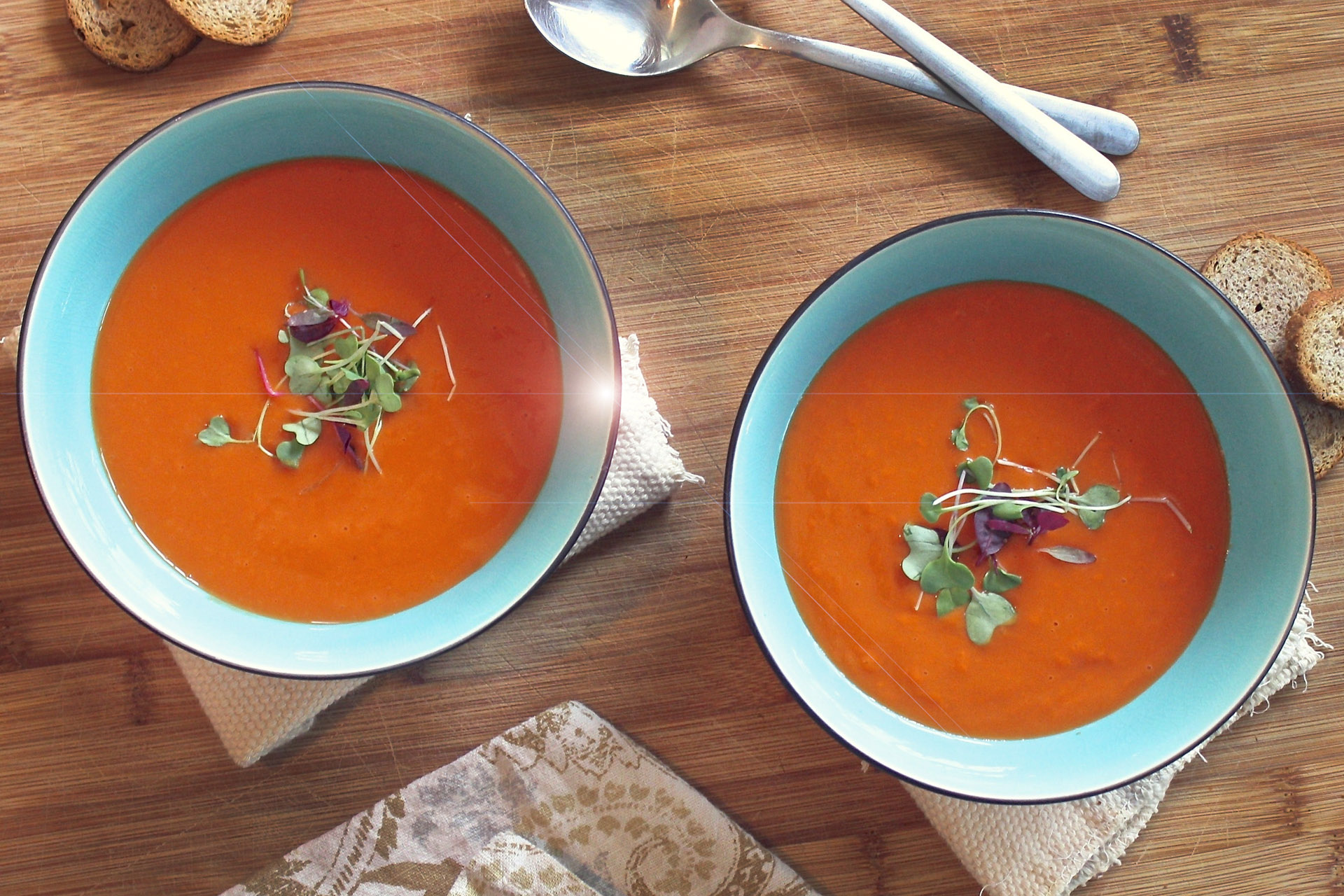 Två blåa tallrikar fyllda med krämig orange soppa.