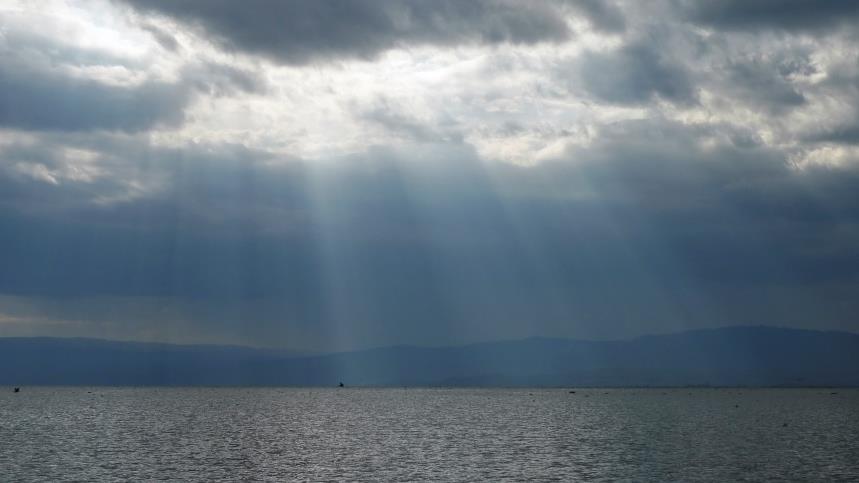 Himmel, hav och moln där solen tränger igenom. 