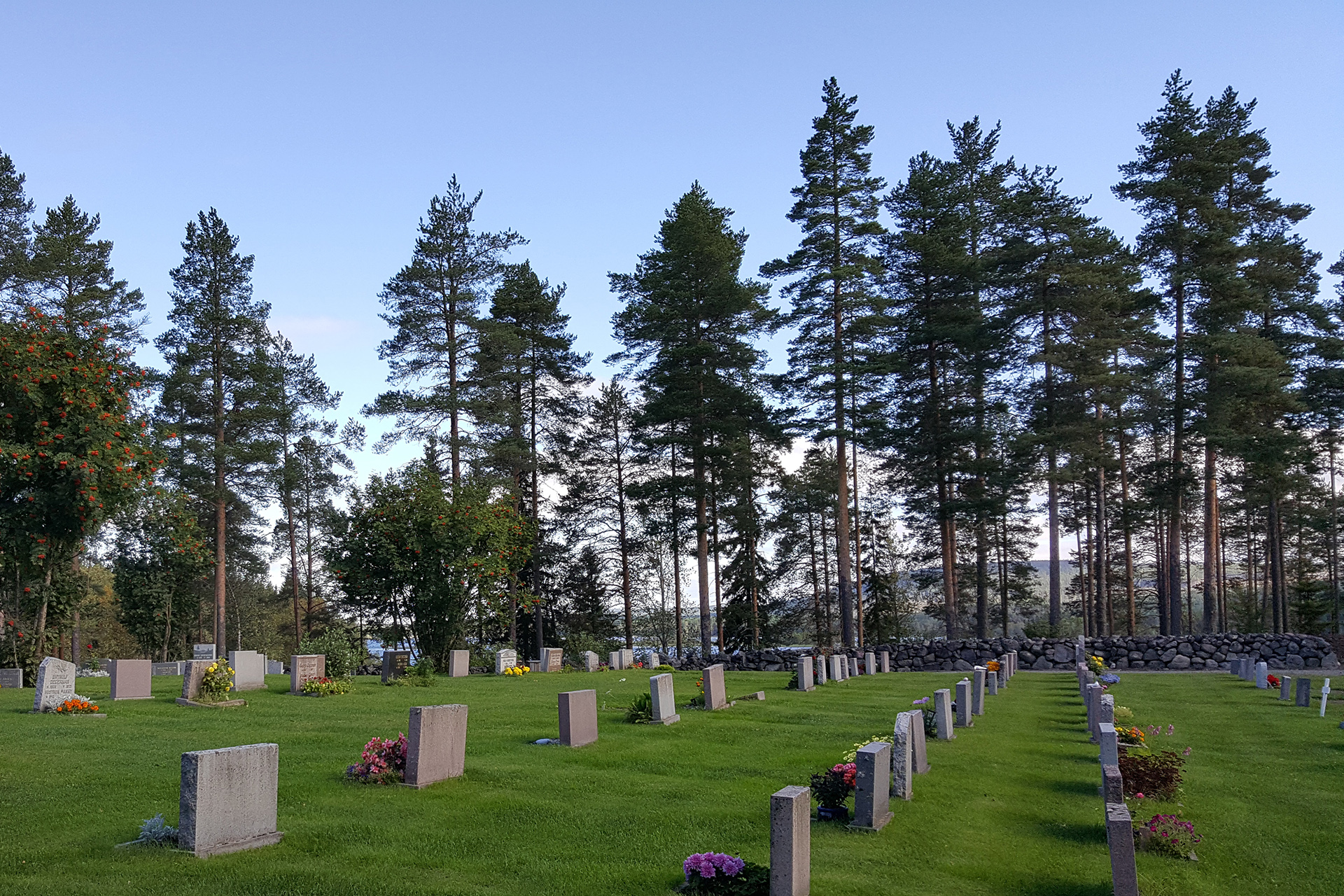 Sommarvy över Gunnarsbyns kyrkogård med utsikt mot Råneälven.