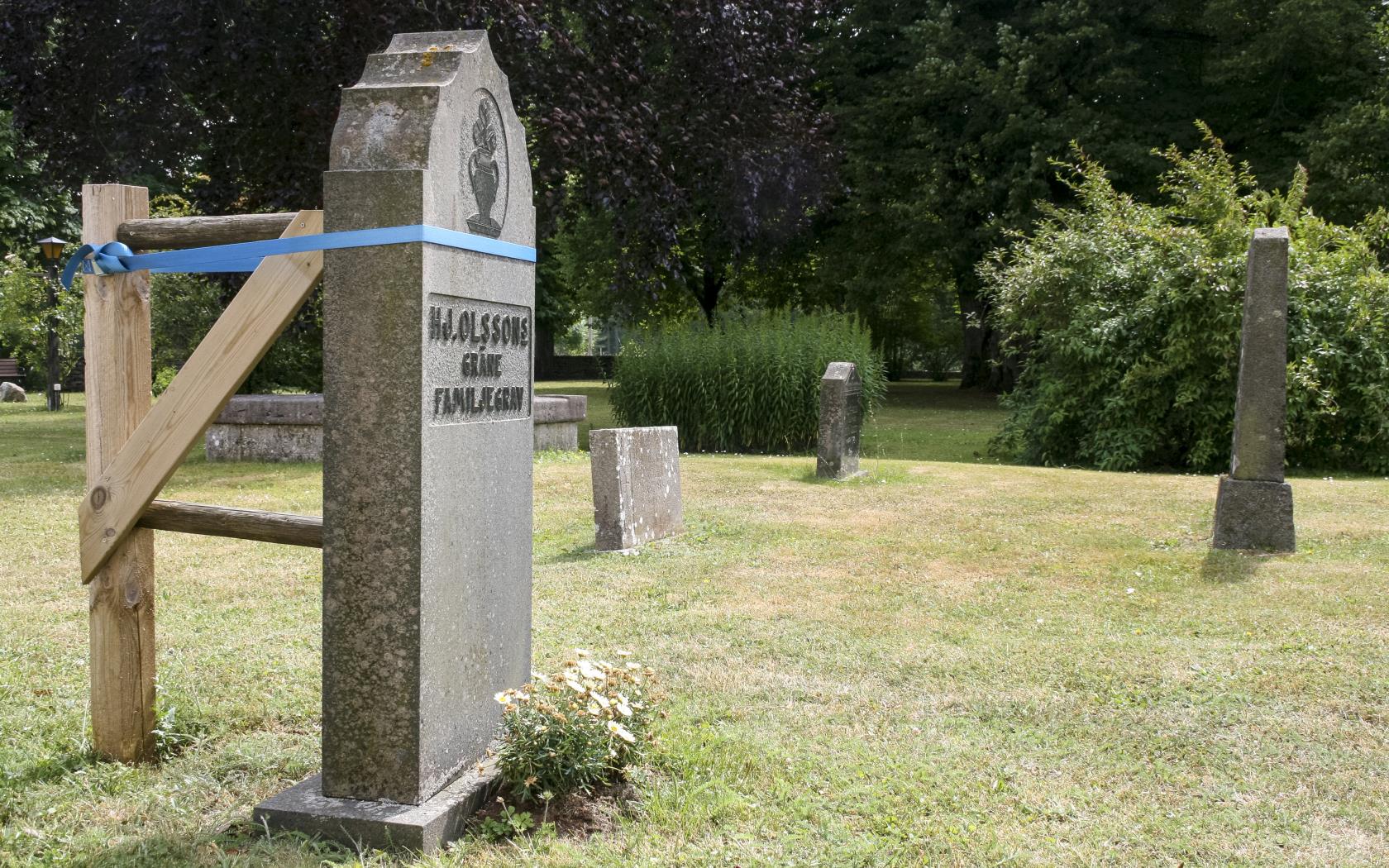 Gravsten på en kyrkogård som stagats upp för att inte falla.