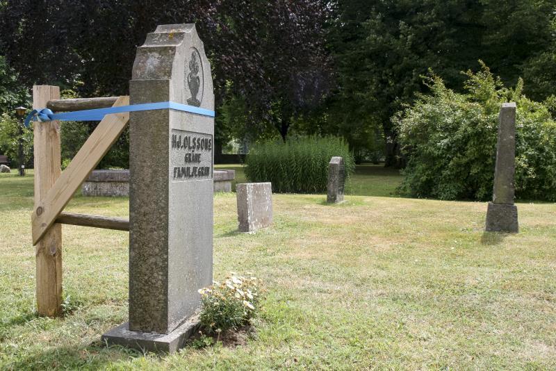 Gravsten på en kyrkogård som stagats upp för att inte falla.