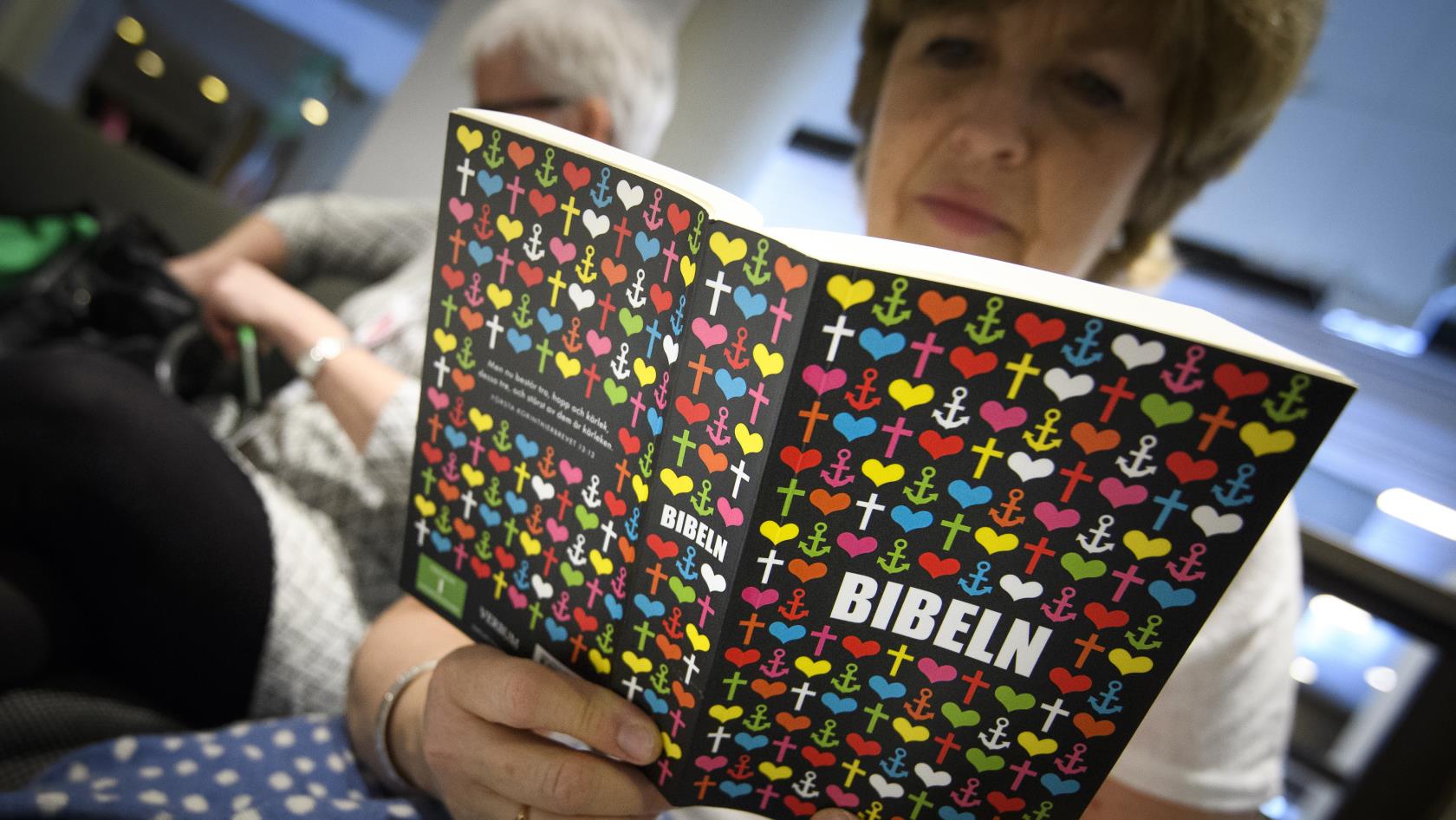 En äldre kvinna läser en bibel.