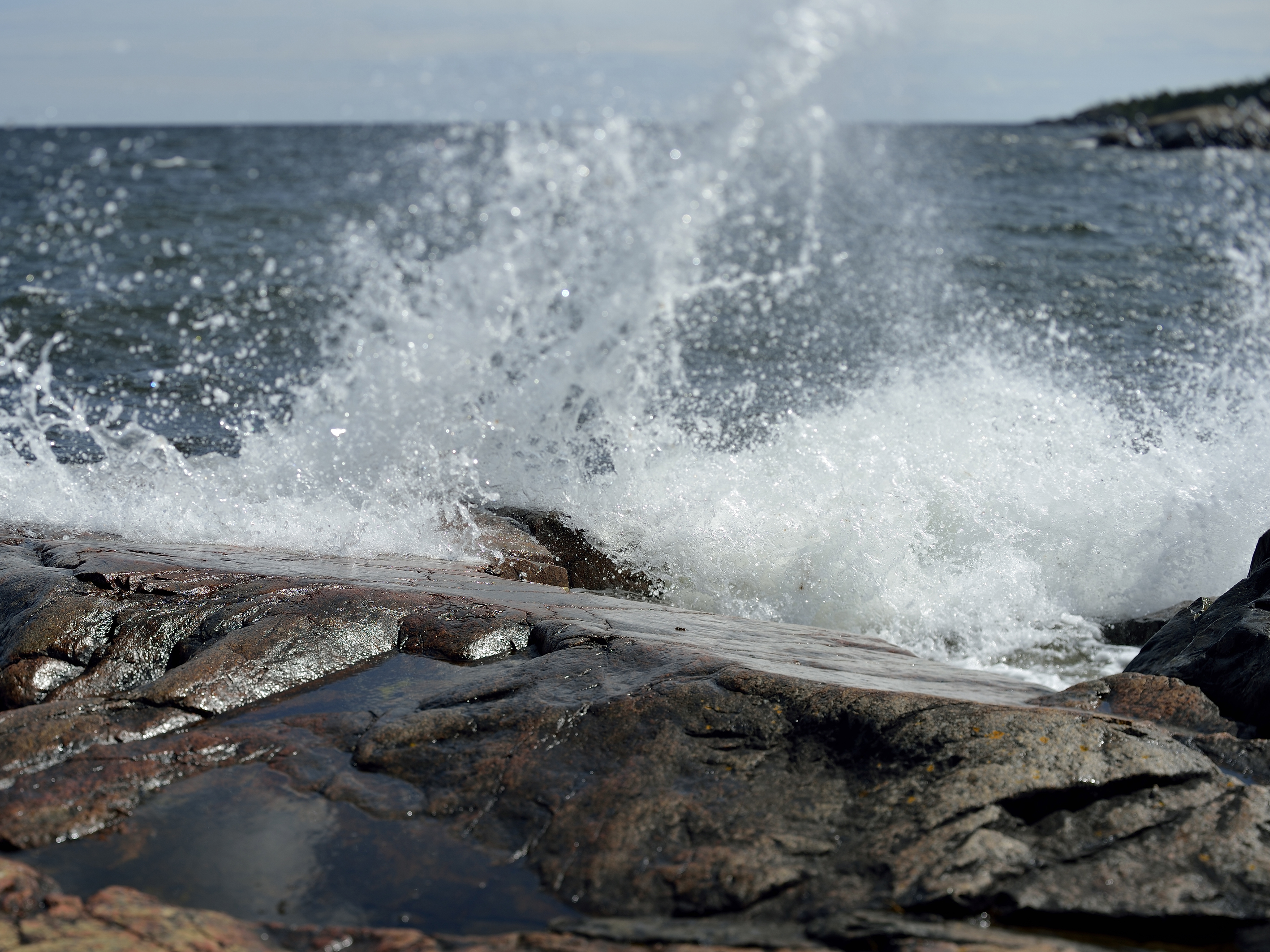 En våg slår mot en klippa.