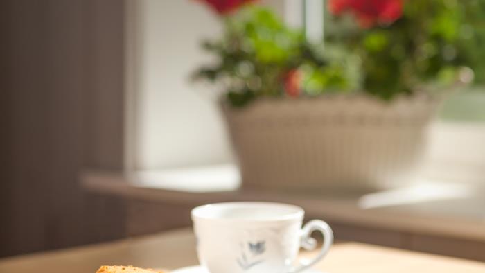 Fikabröd och en kopp kaffe står på ett bord.