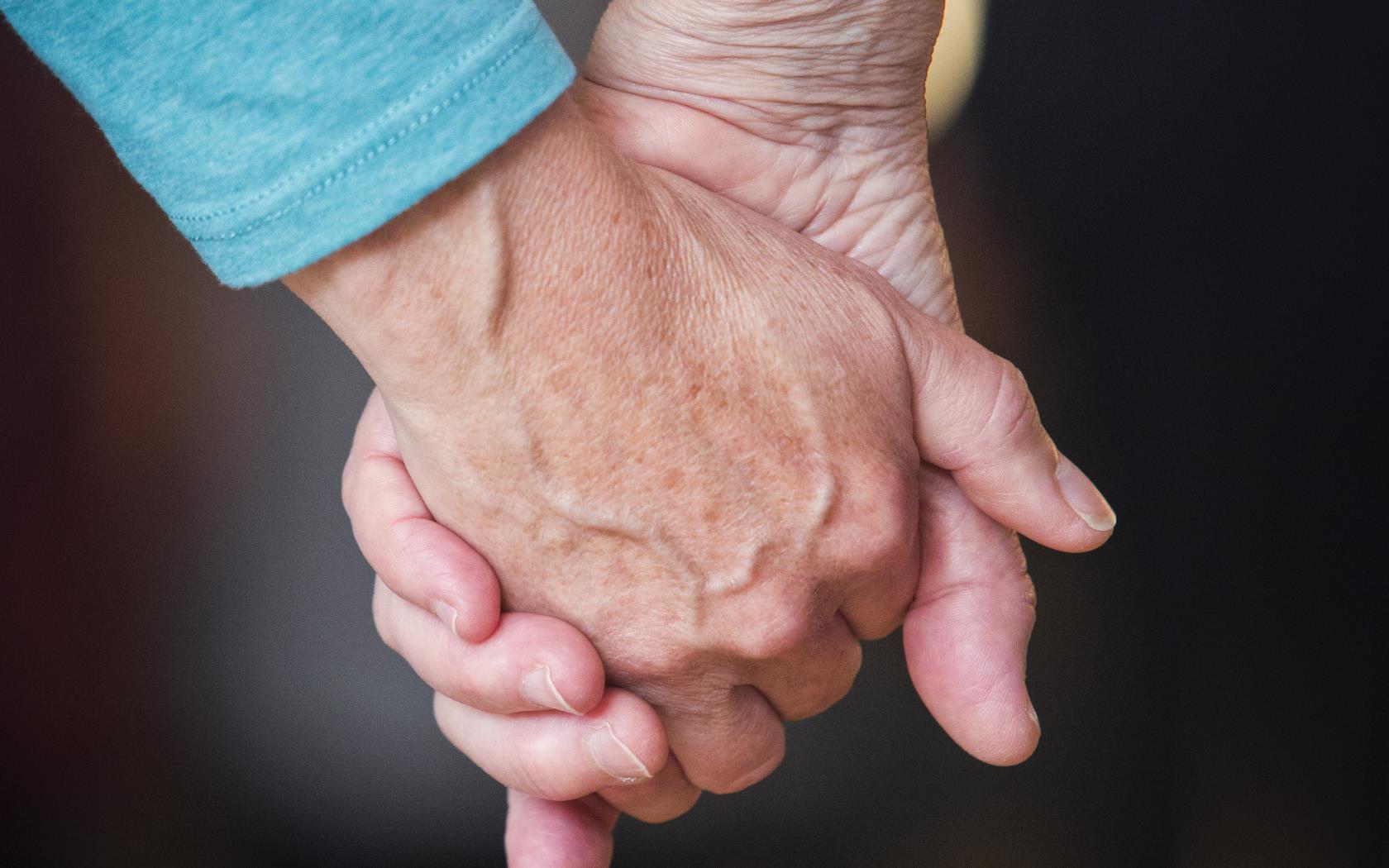 Två personer håller hand.