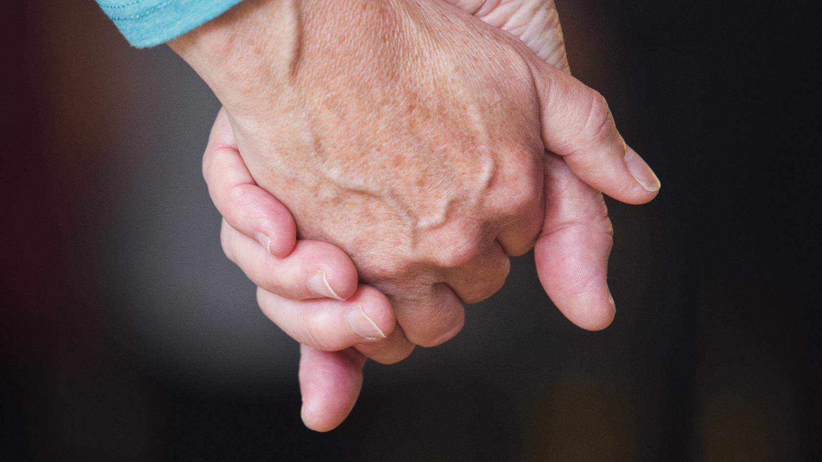 Två personer håller hand.