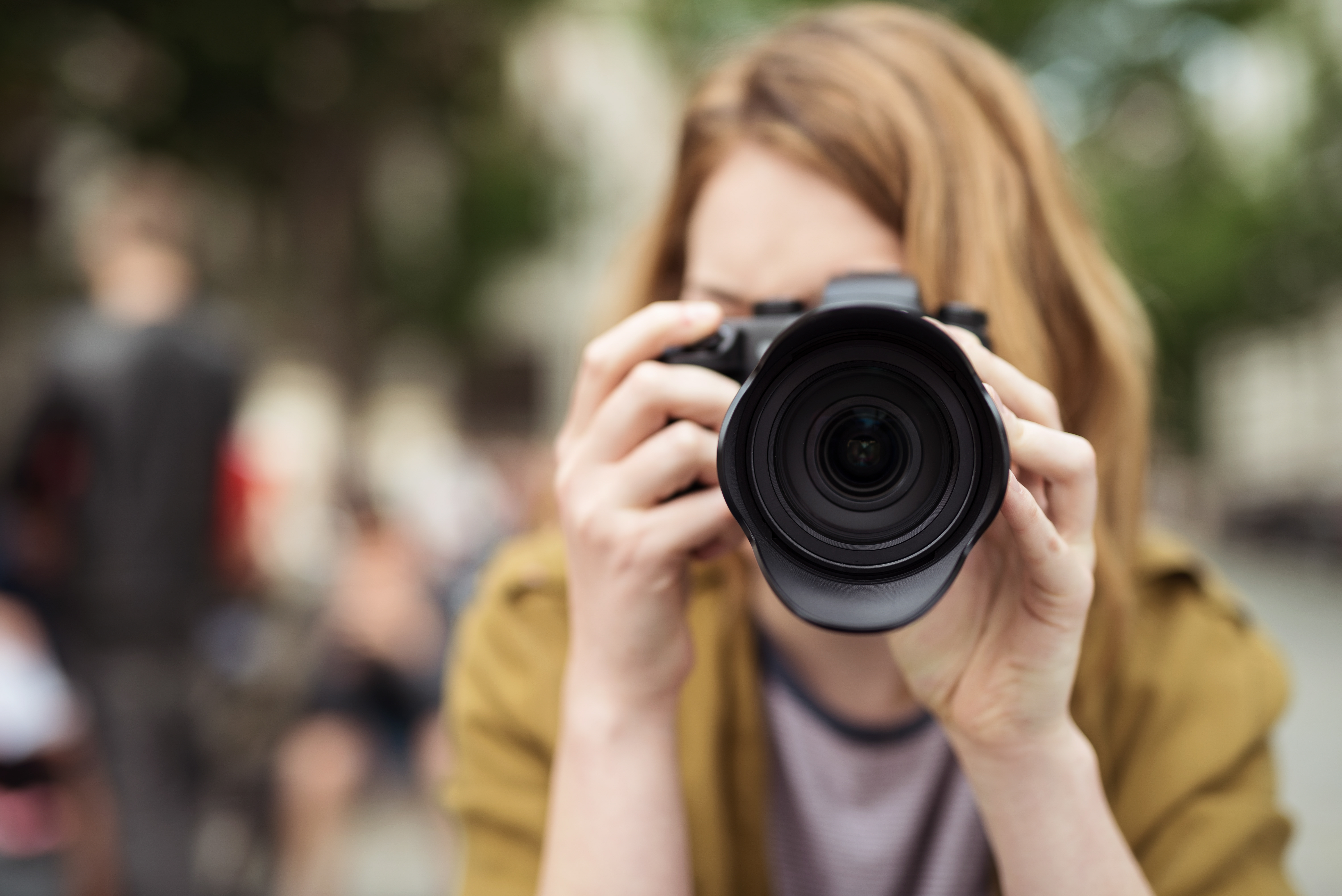 En kvinna fotograferar utomhus.