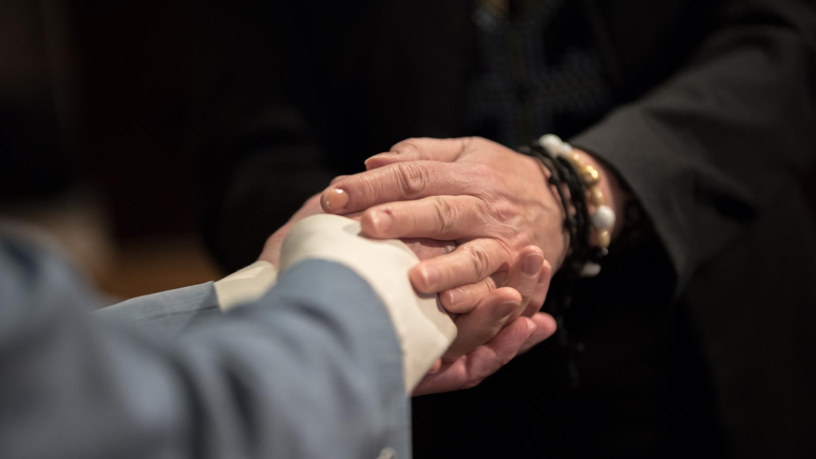 Två personer håller i varandras händer.