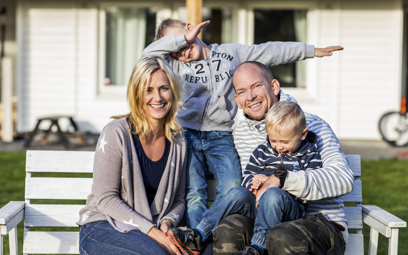 Ett familjefoto utomhus. En av sönerna gör en gest med armarna.