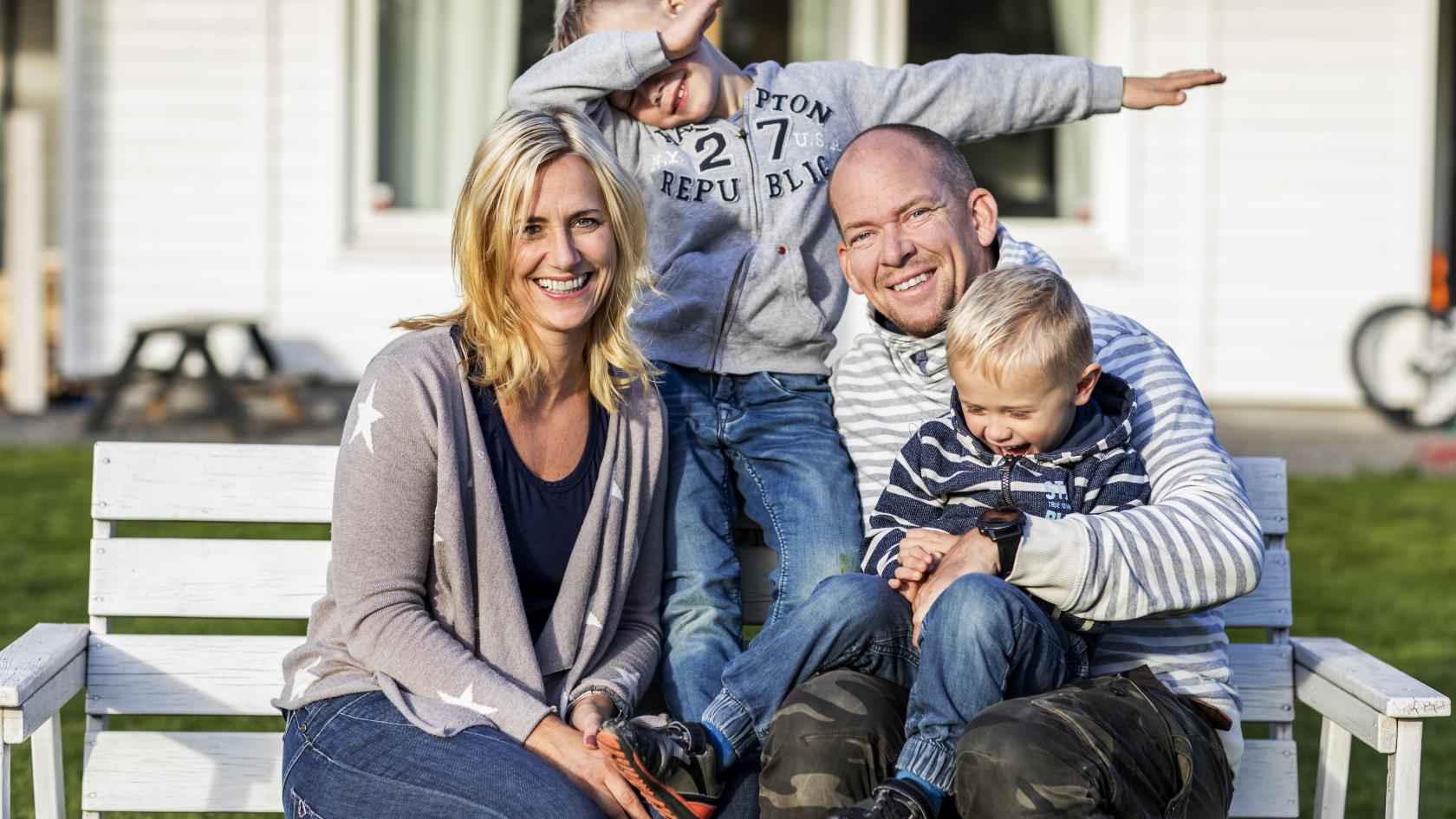 Ett familjefoto utomhus. En av sönerna gör en gest med armarna.