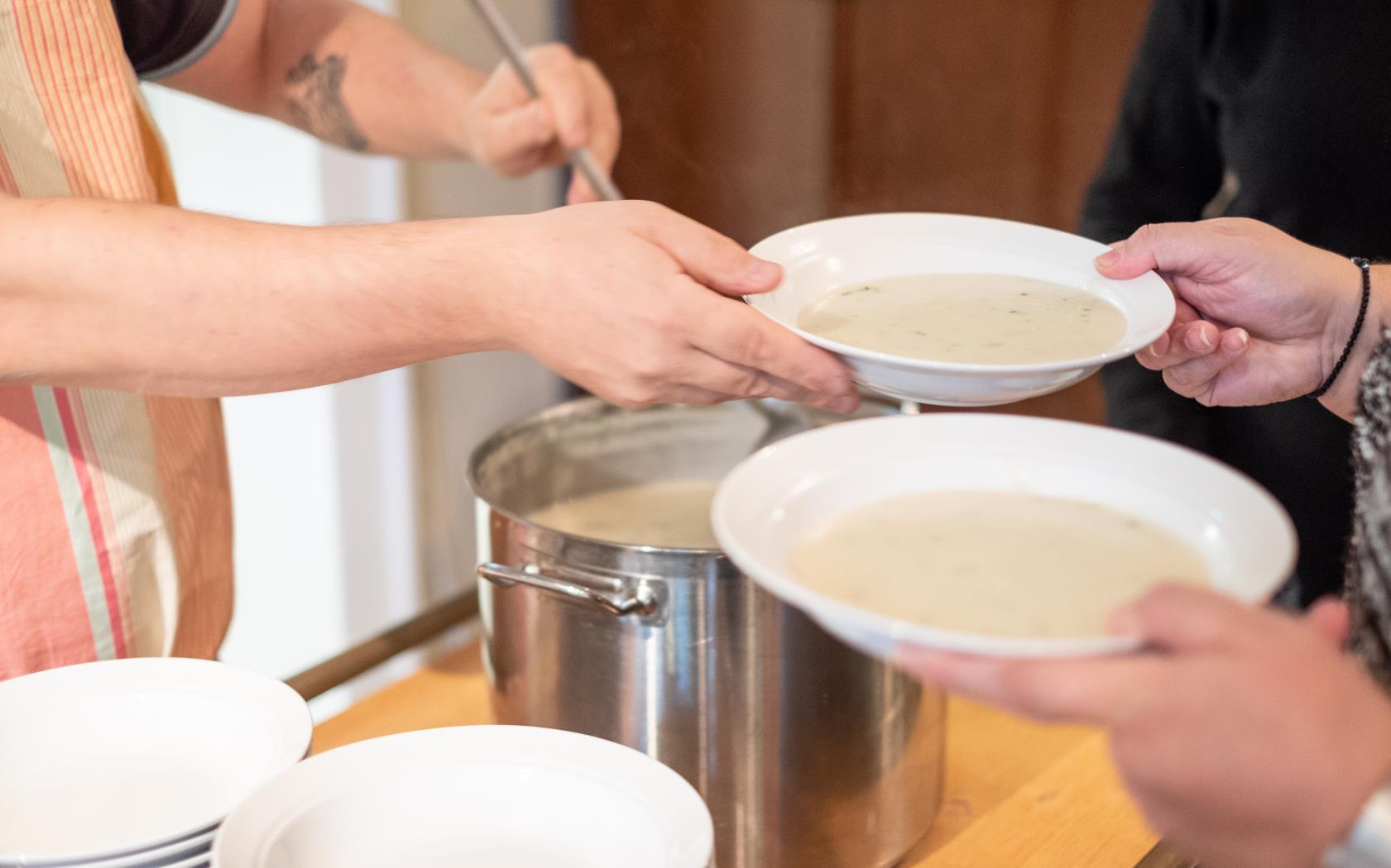 Någon står och serverar soppa.