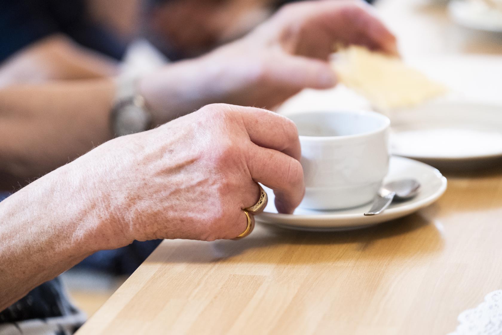 Någon lyfter upp en kaffekopp.