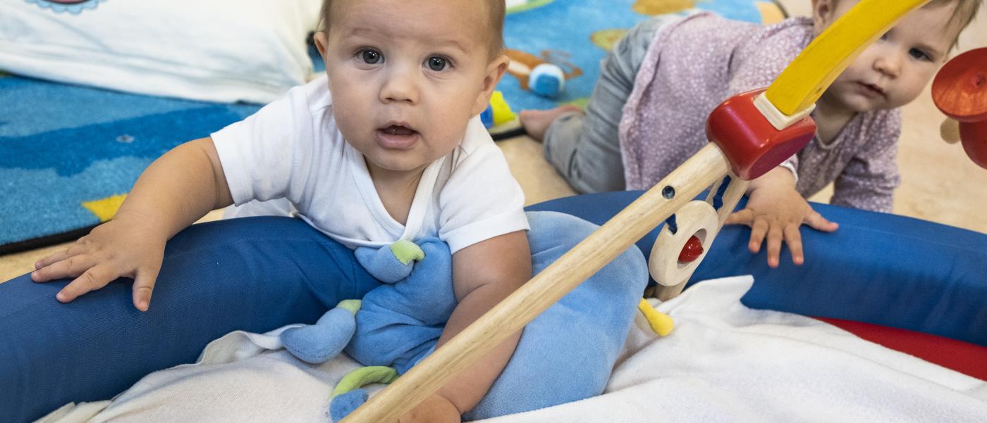 Två bebis klättrar in i ett babygym.