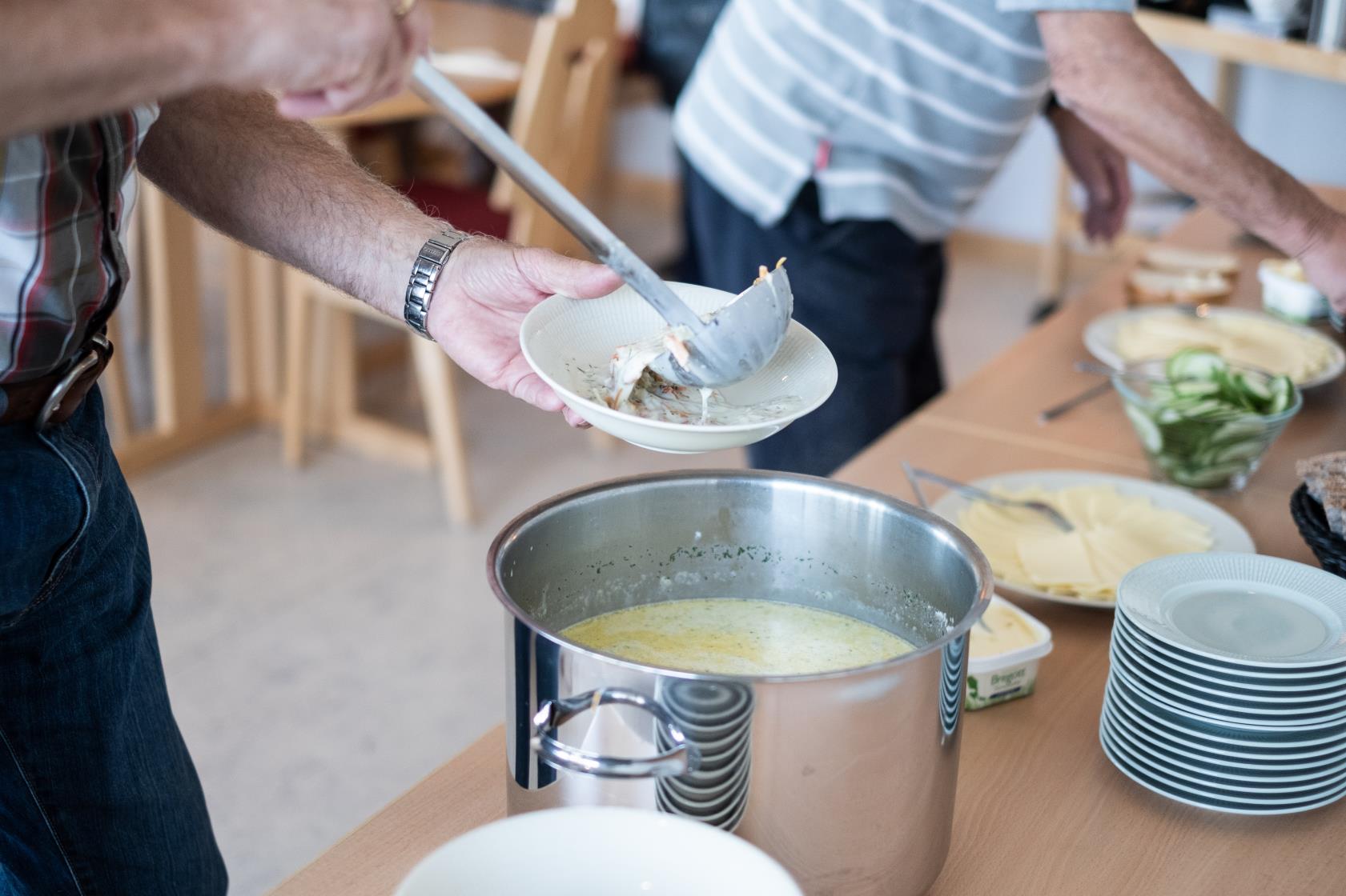 Någon tar en slev soppa ur en kastrull.