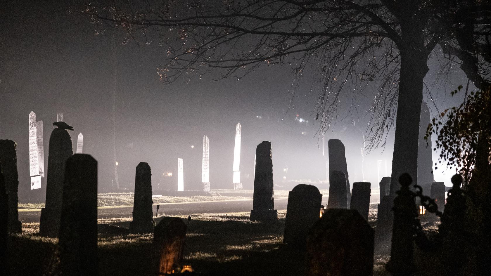 En mörk kyrkogård som lyses upp av en strålkastare.