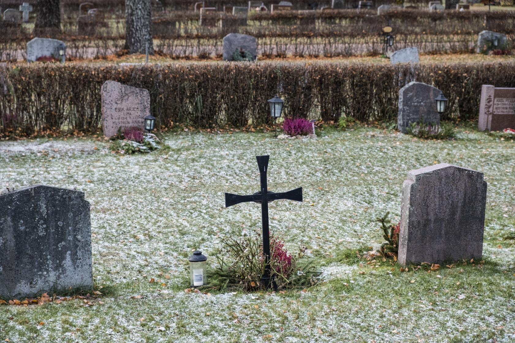 Den första snön har just fallit på en kyrkogård.