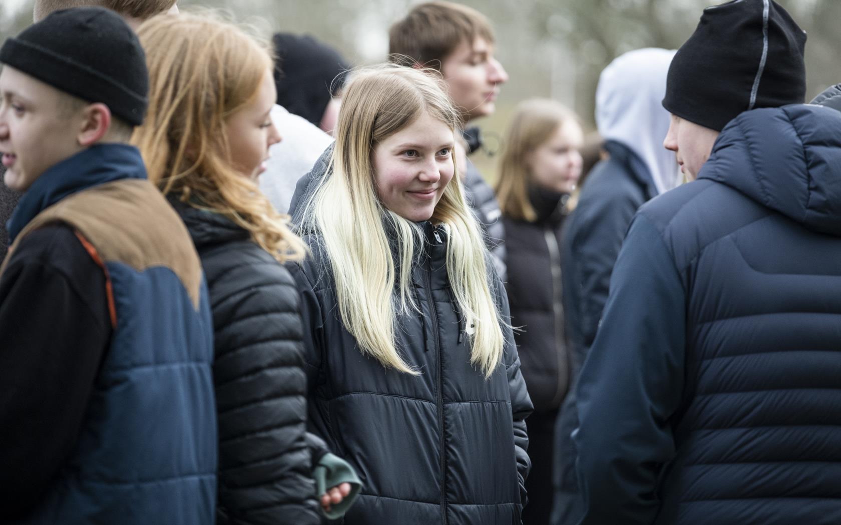 Ett gäng ungdomar står samlade utomhus.