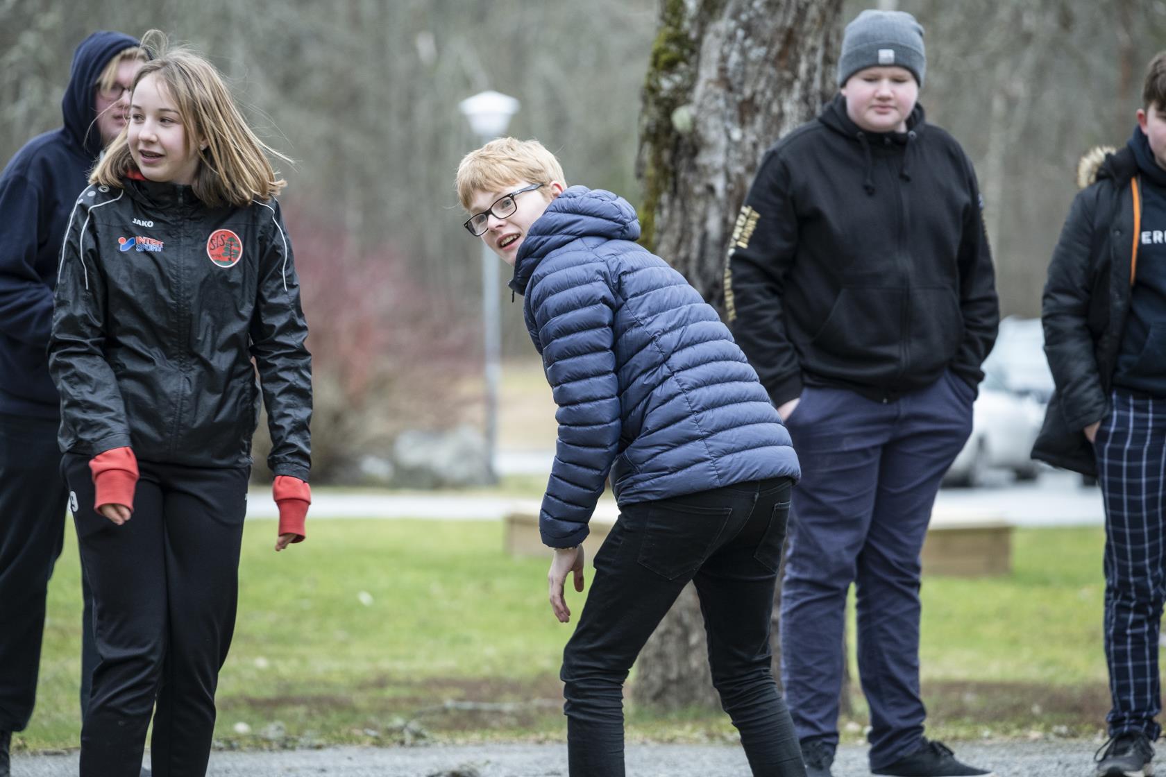 Några ungdomar leker utomhus.