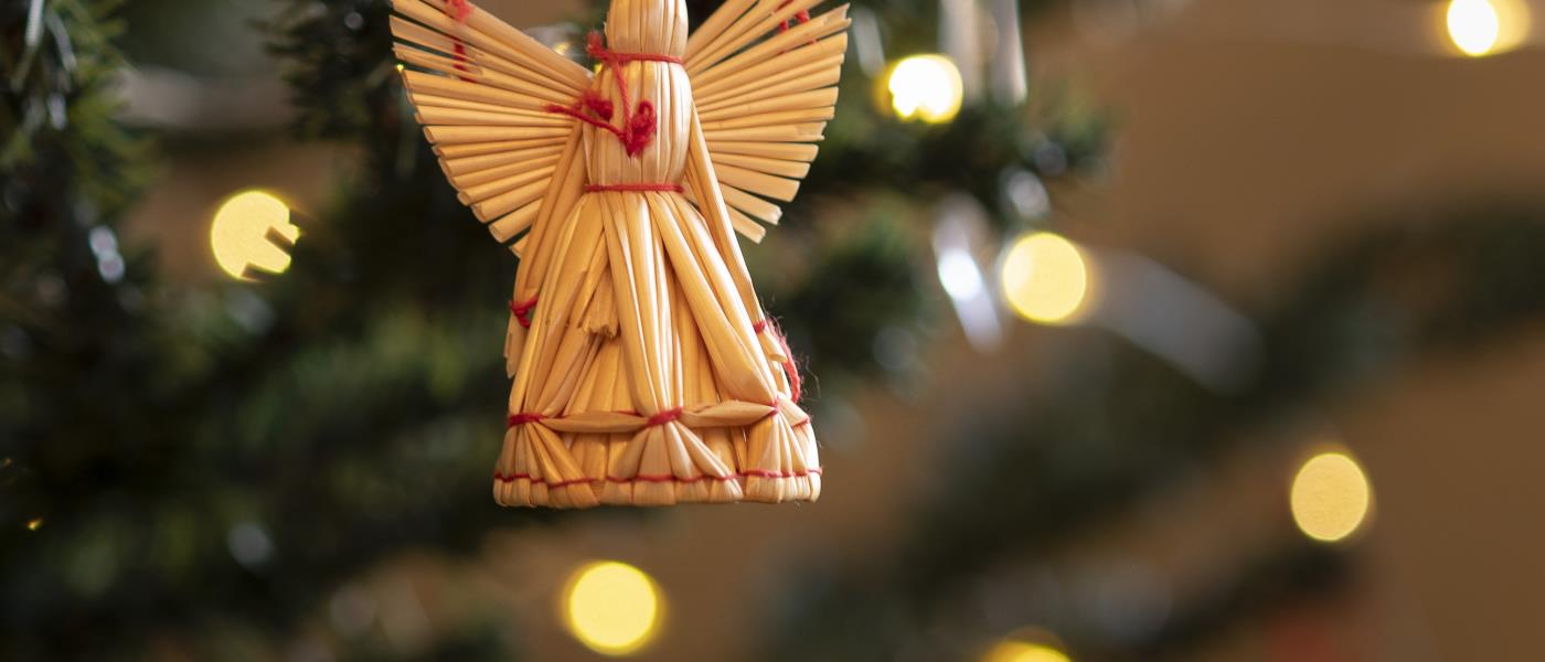 En halmängel hänger som dekoration i en julgran.