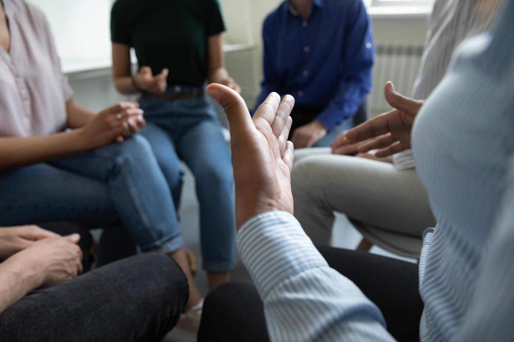 En grupp människor sitter i en ring och samtalar.