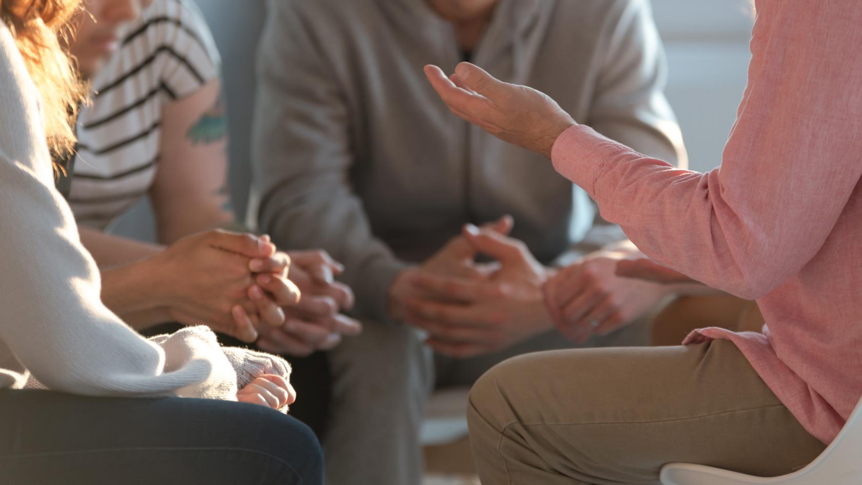 En grupp människor sitter i en liten ring och samtalar.