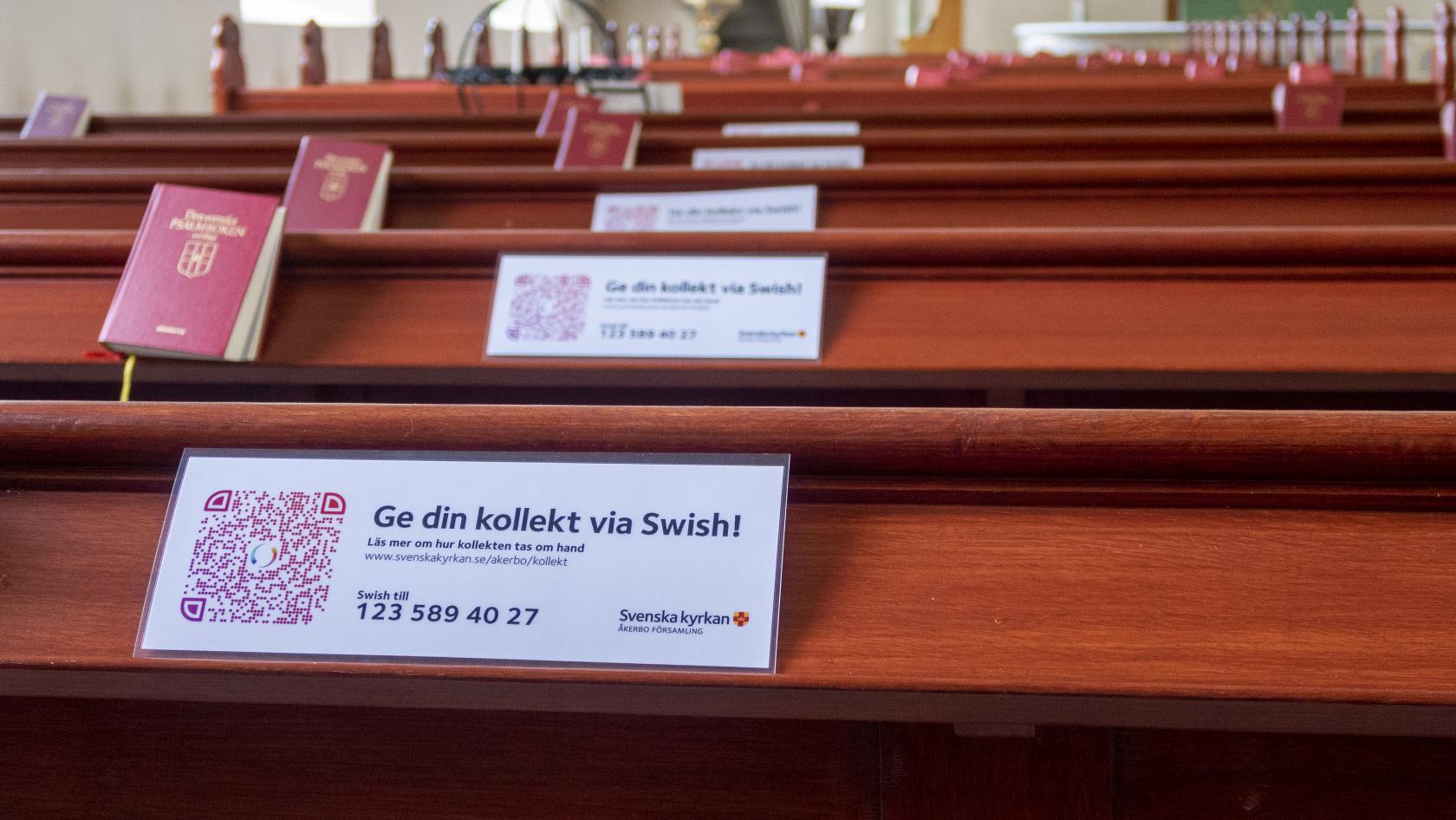 Lappar med texten Ge din kollekt via Swish ligger i kyrkbänkarna.