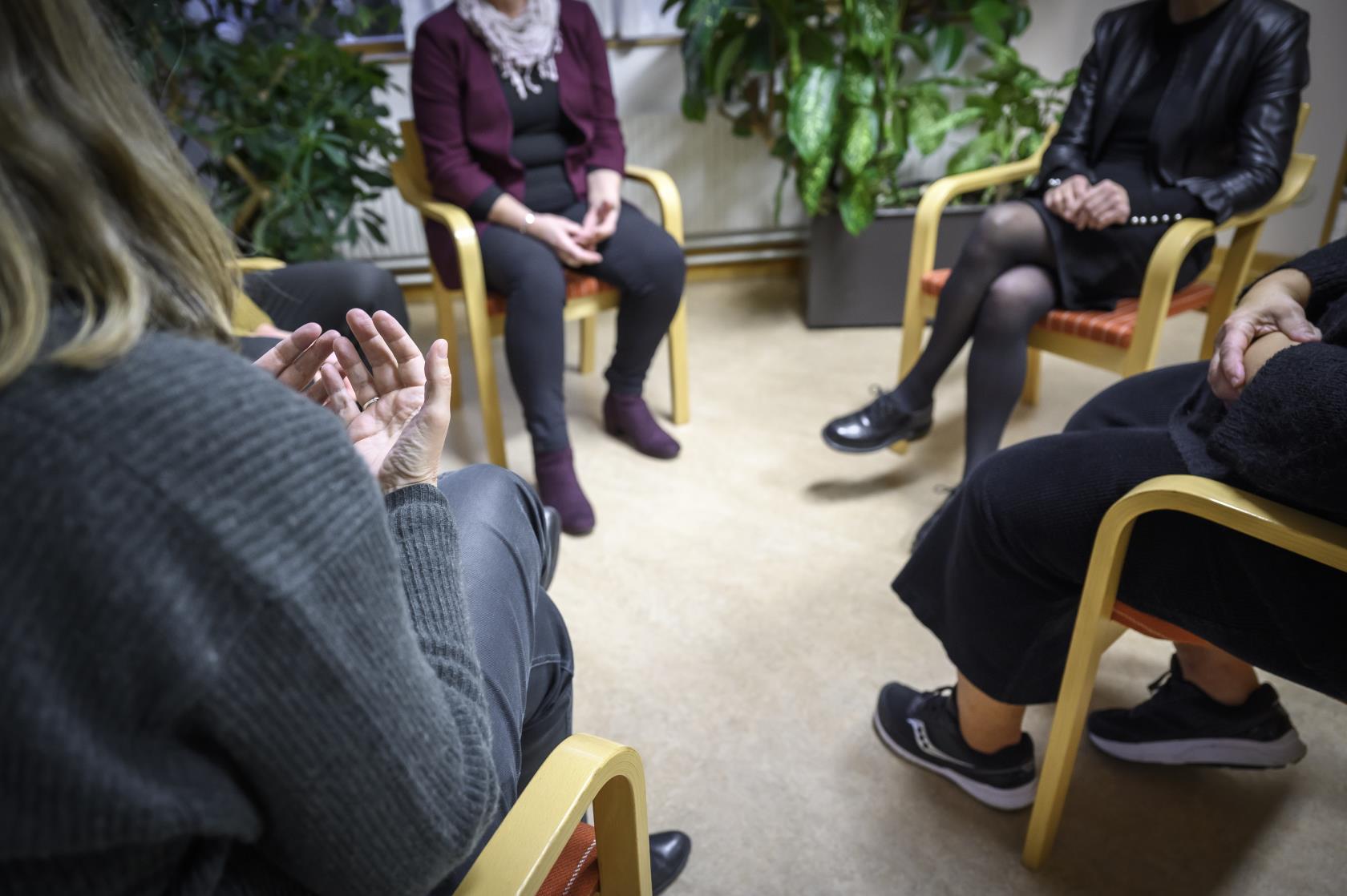 Några personer sitter och samtalar inomhus.