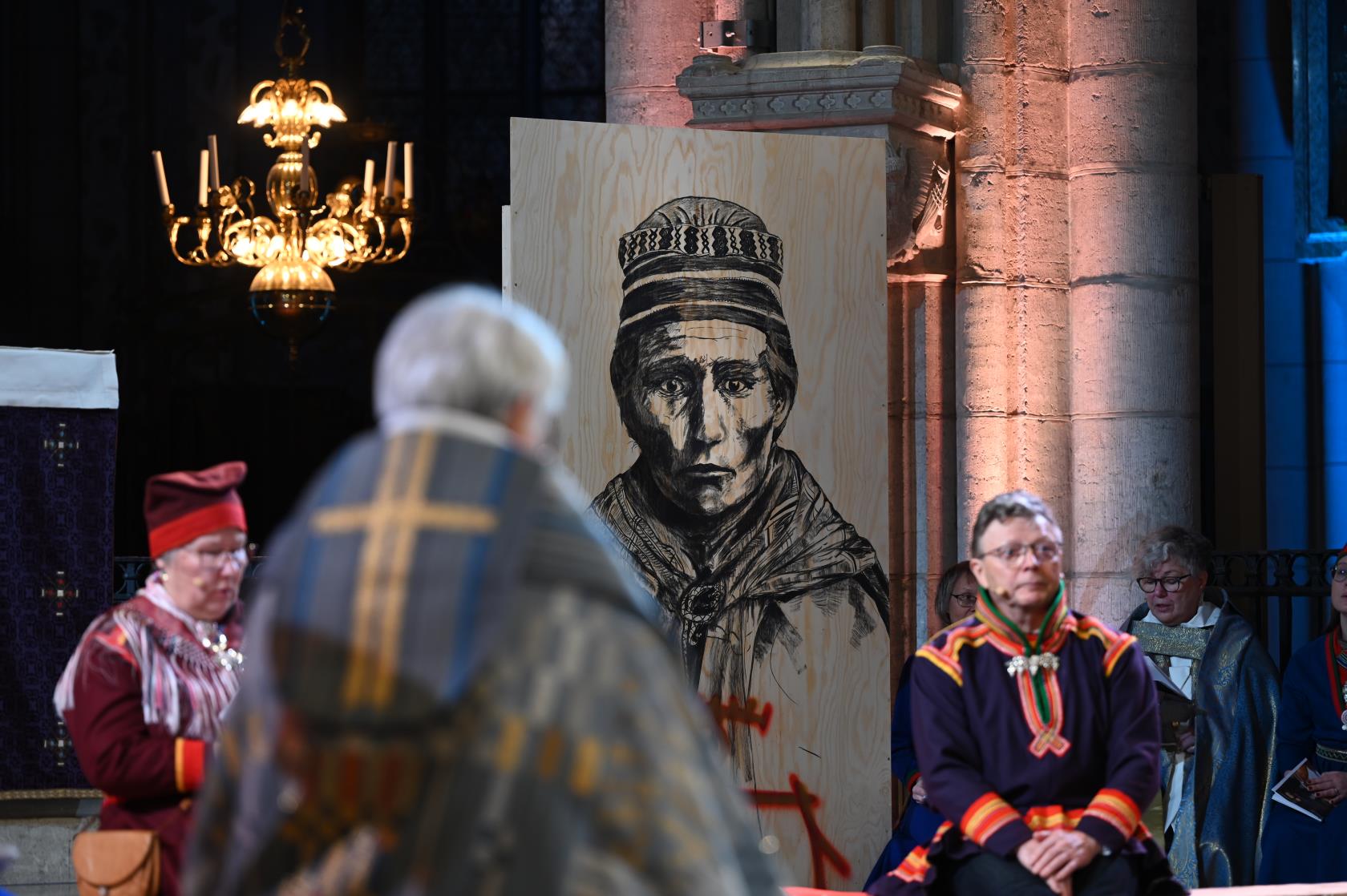 Ett svartvitt sameporträtt tryckt på en spånskiva står i Uppsala domkyrka.