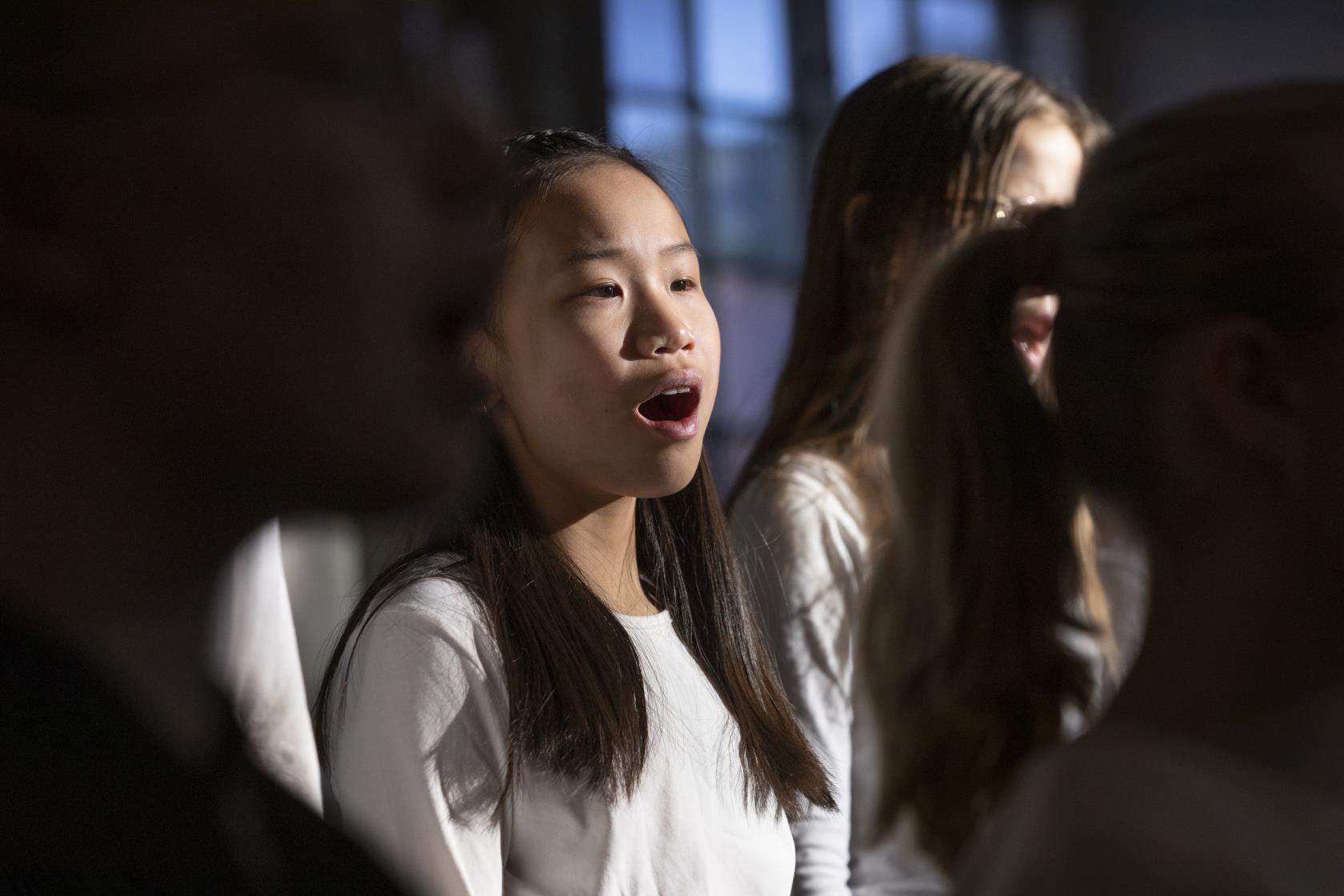 Närbild på medlemmar i en barnkör som sjunger i en kyrka.