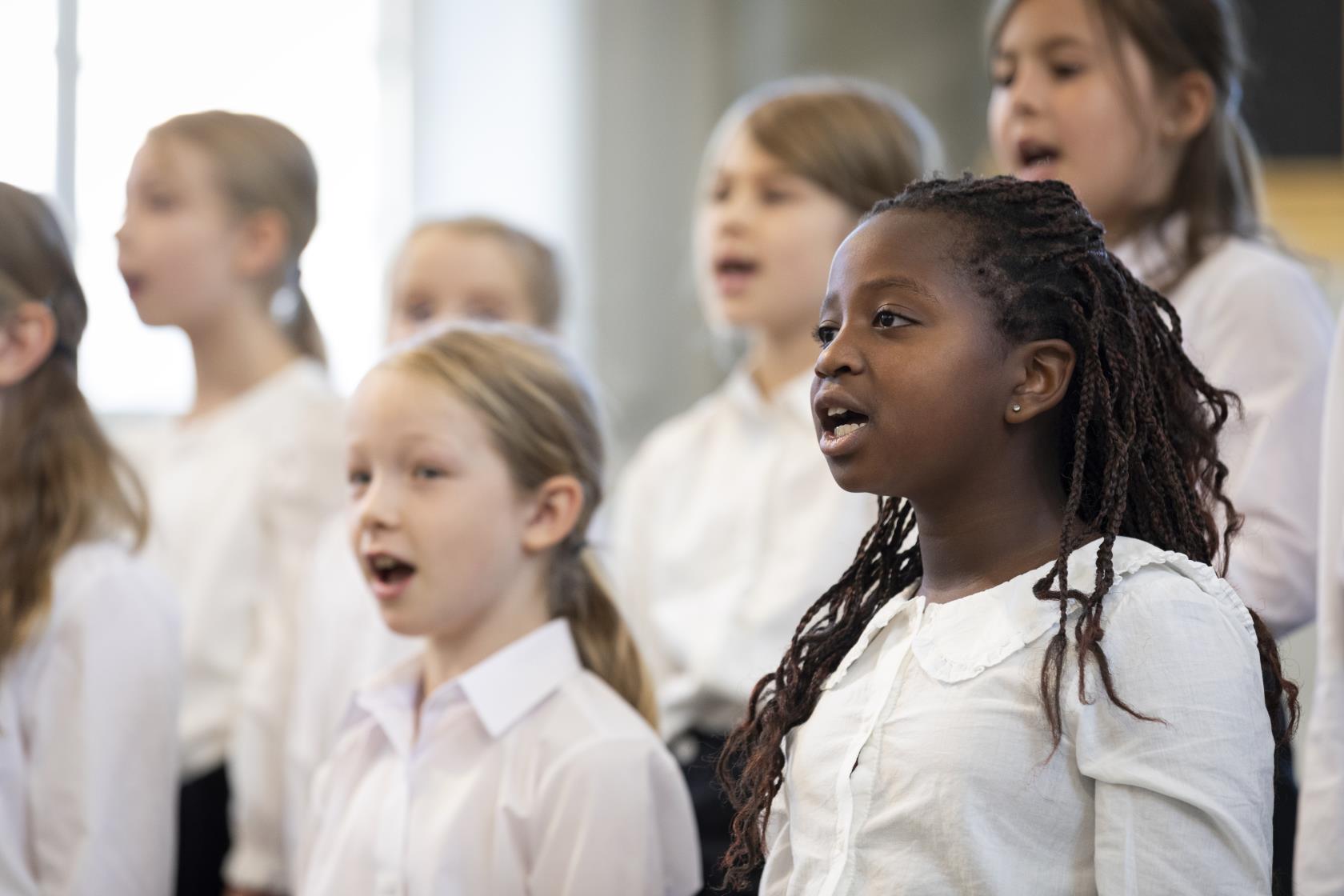 Medlemmar i en barnkör står och sjunger i en kyrka.