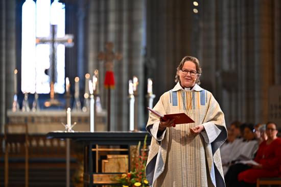 En kvinnlig biskop står framför altaret i Uppsala domkyrka och pratar.