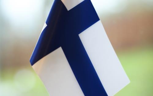 En finsk bordsflagga står i ett fönster.