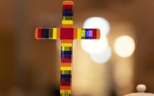 Närbild på ett kors i olika färger.