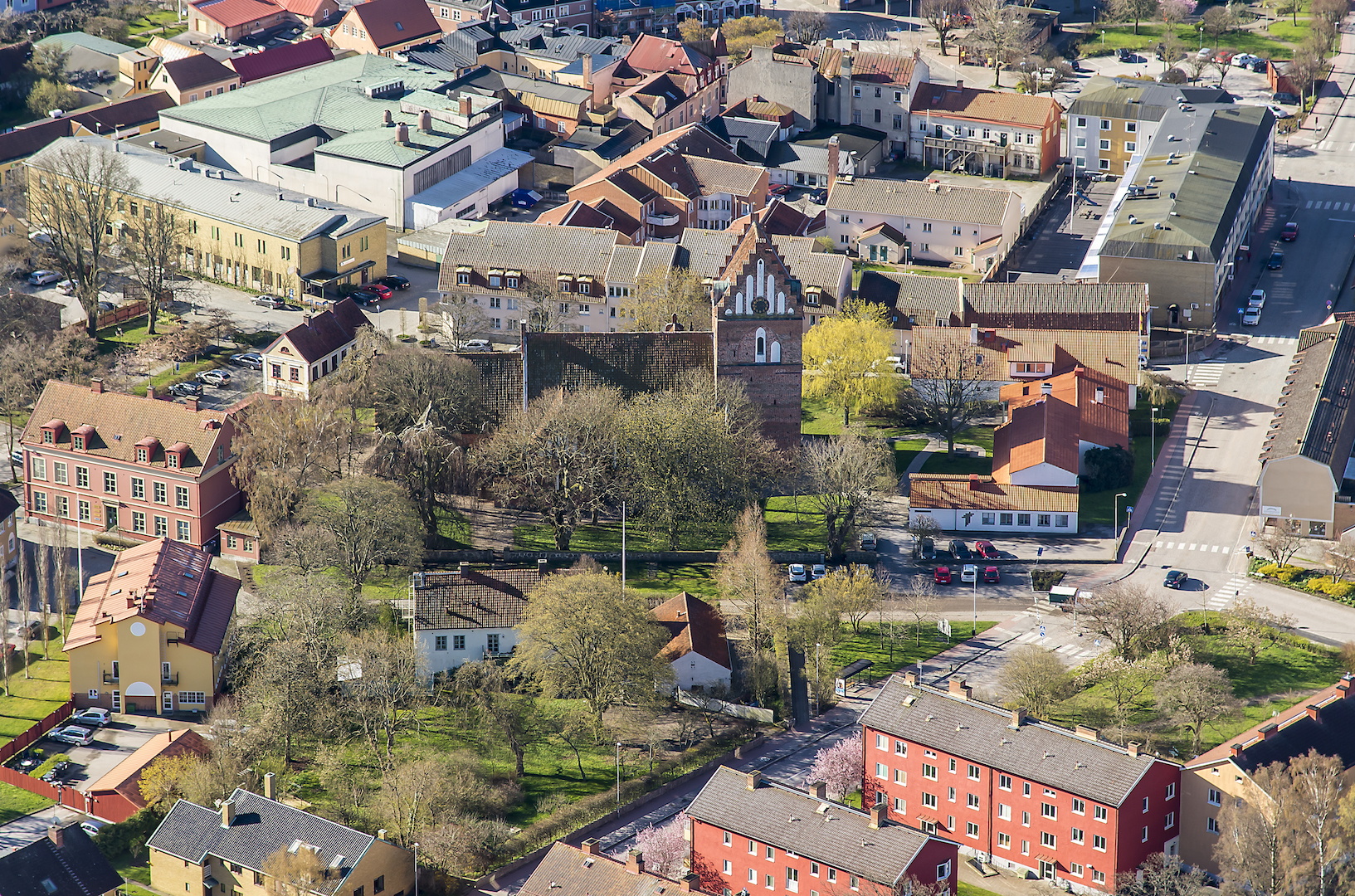 Röd tegelkyrka med trappstensgavlar, mitt i stan.